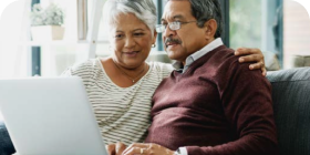 Man and woman sitting down and looking at a laptop