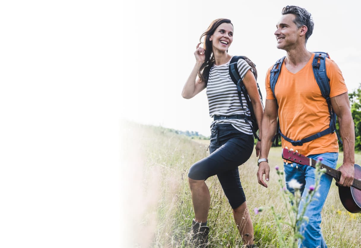 Man with guitar hiking with woman